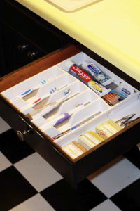 Use a kitchen utensil divider to store toothbrushes and other bathroom stuff