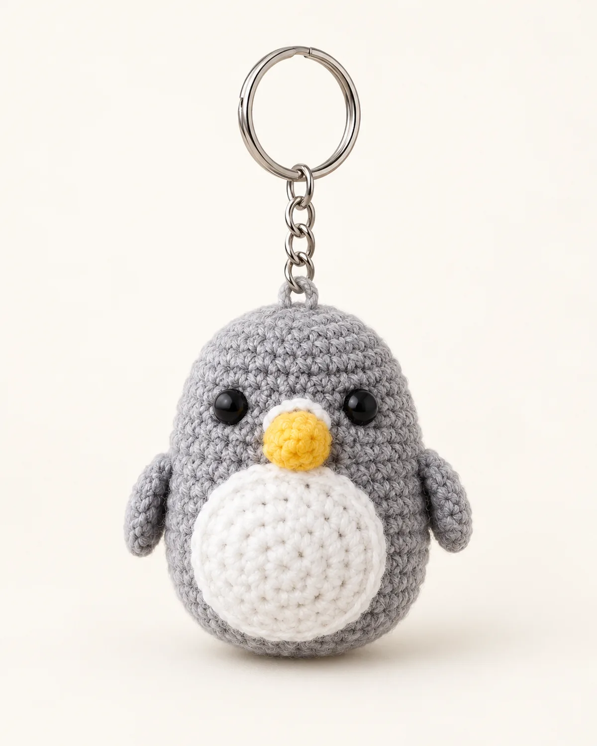 Mini Penguin Keychain, finished product on a warm off-white background